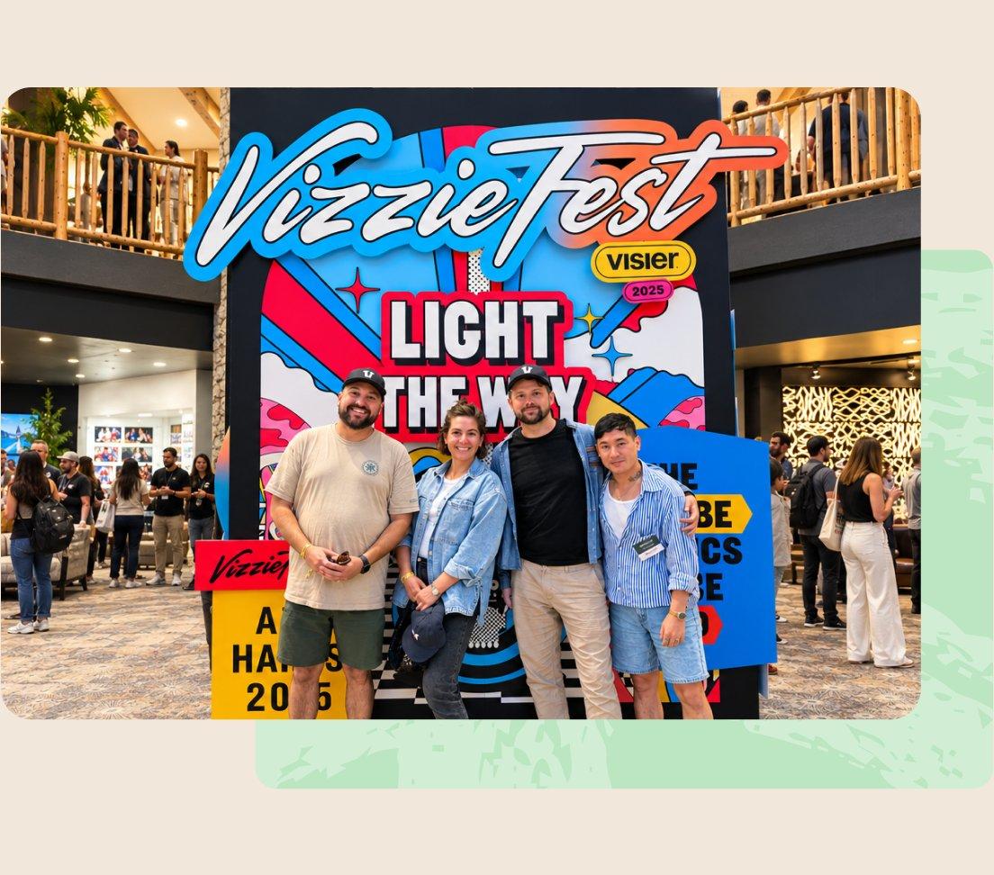 Four Visier employees posing in front of the VizzieFest Light the Way sign