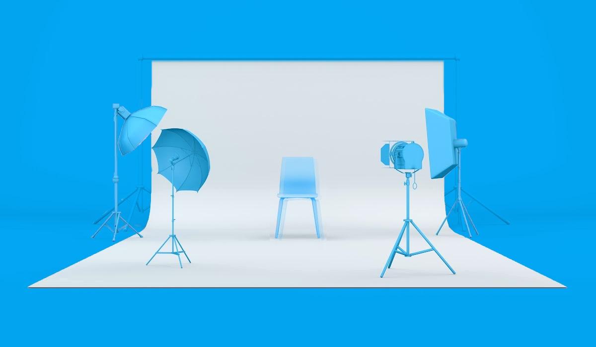 an empty photo studio with lights and a chair in the center against a white backdrop