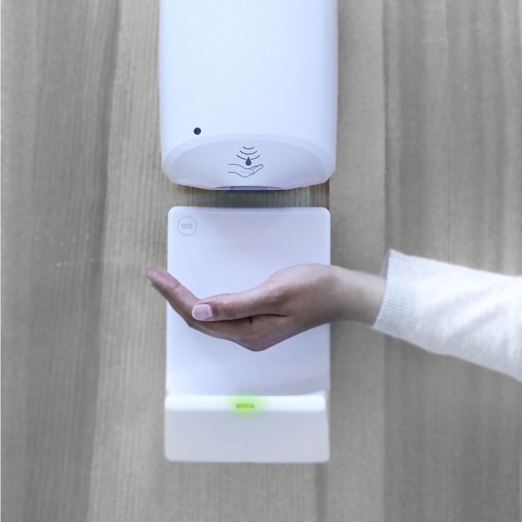 Image of the SwipeSense dripguard in action. A hand is underneath the sanitation device while a sensor directly below it activates the drip function and logs the hygiene event