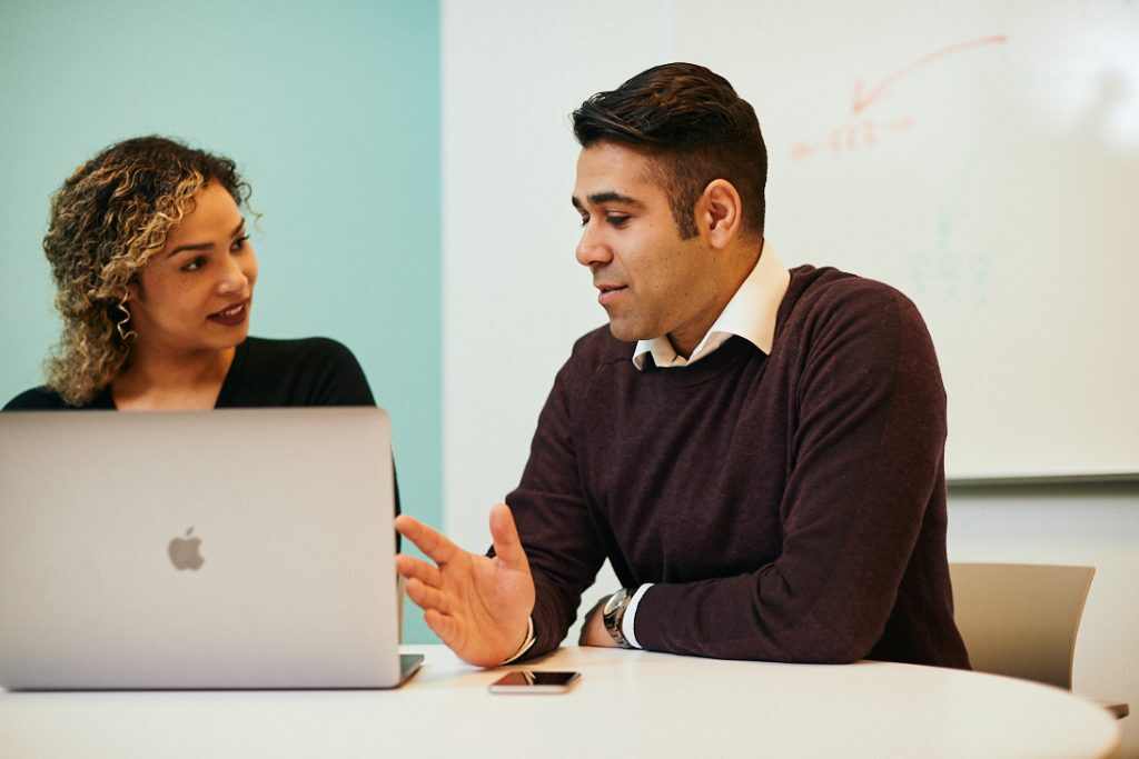Business man speaking with dedicated customer success woman in a meeting room