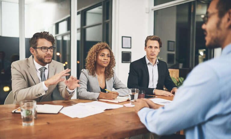 shot of a group of businesspeople interviewing a candidate in an
